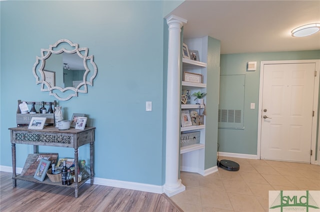 entryway with decorative columns, baseboards, and tile patterned flooring