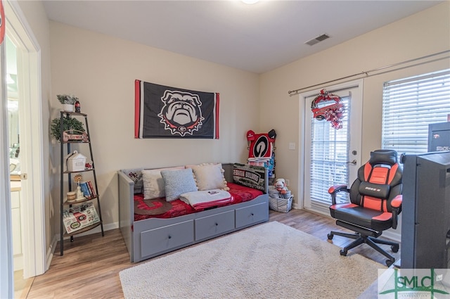 bedroom with light wood-type flooring, access to exterior, baseboards, and visible vents