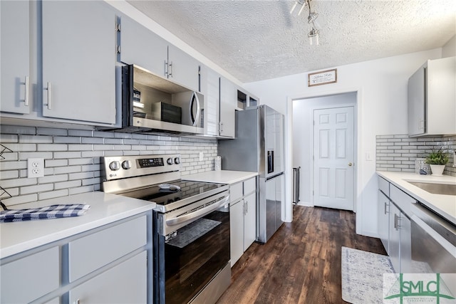 kitchen featuring backsplash, dark hardwood / wood-style flooring, a textured ceiling, sink, and stainless steel appliances