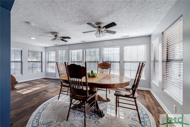 dining area with ceiling fan, a wealth of natural light, dark hardwood / wood-style flooring, and a textured ceiling