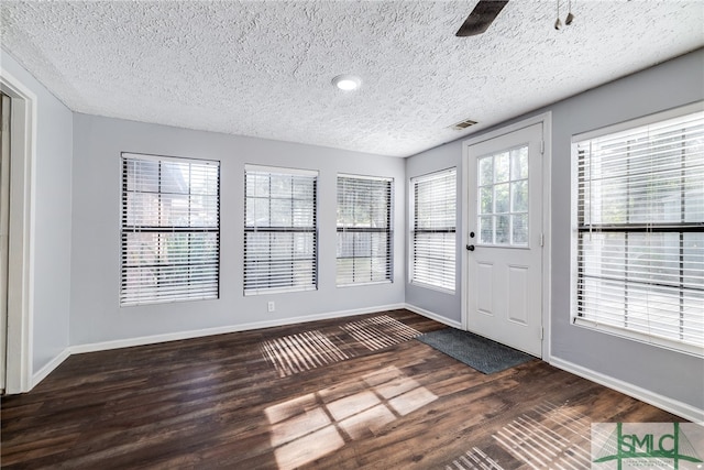 interior space with dark wood-type flooring, a textured ceiling, and ceiling fan