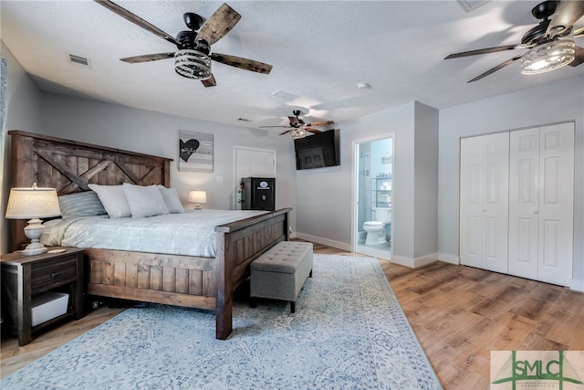 bedroom featuring a closet, ensuite bathroom, light hardwood / wood-style floors, and ceiling fan