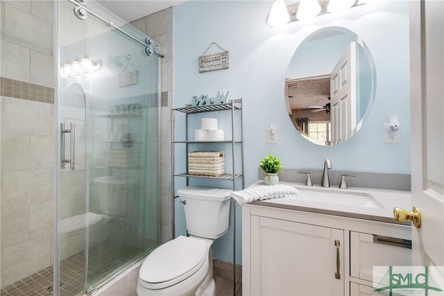 bathroom with vanity, a shower with shower door, and toilet