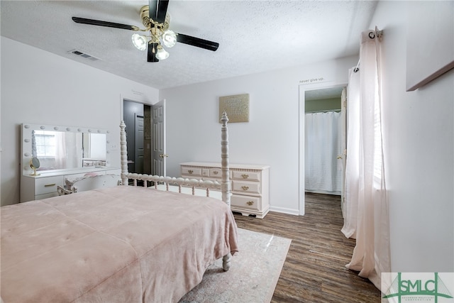 bedroom featuring dark hardwood / wood-style flooring, a textured ceiling, and ceiling fan