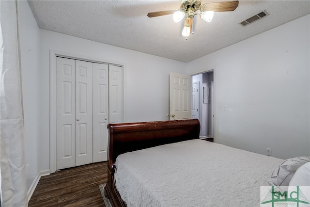 bedroom featuring dark hardwood / wood-style flooring, a closet, a textured ceiling, and ceiling fan