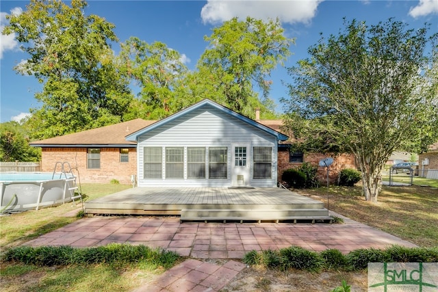 rear view of property with a pool side deck