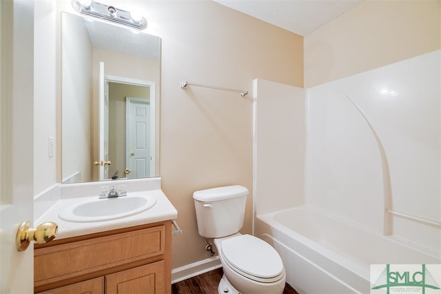 full bathroom with toilet, wood-type flooring,  shower combination, vanity, and a textured ceiling