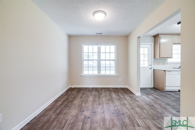 unfurnished dining area with a wealth of natural light, hardwood / wood-style floors, and a textured ceiling