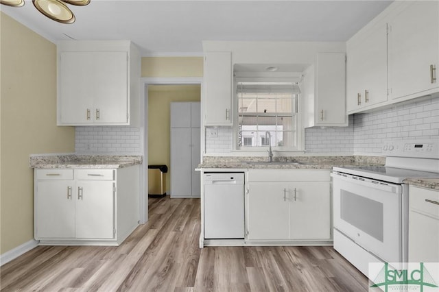 kitchen featuring white appliances, tasteful backsplash, light hardwood / wood-style floors, white cabinets, and sink