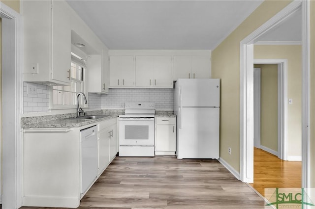 kitchen with white appliances, white cabinets, light hardwood / wood-style flooring, and sink