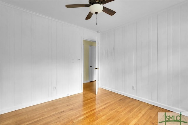 spare room with hardwood / wood-style flooring, ceiling fan, and ornamental molding