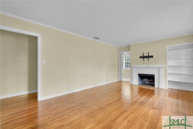 unfurnished living room with built in features, crown molding, and wood-type flooring