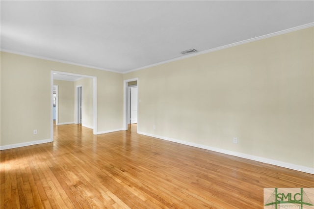 spare room featuring light hardwood / wood-style floors and crown molding