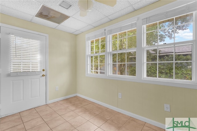 interior space featuring ceiling fan, a paneled ceiling, and light tile patterned floors