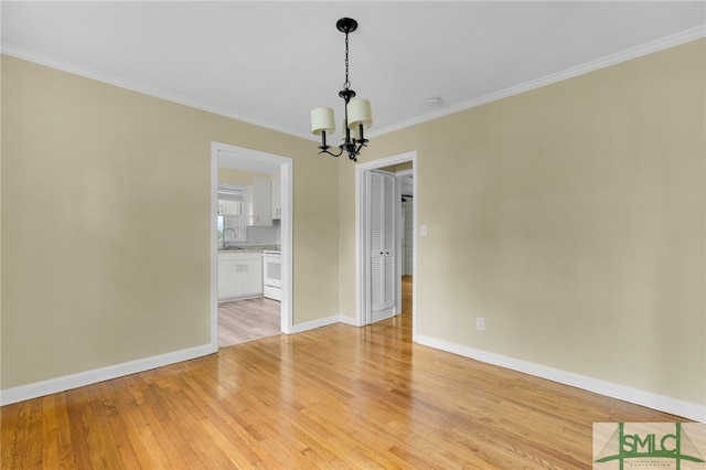 unfurnished dining area with sink, crown molding, light hardwood / wood-style floors, and a notable chandelier