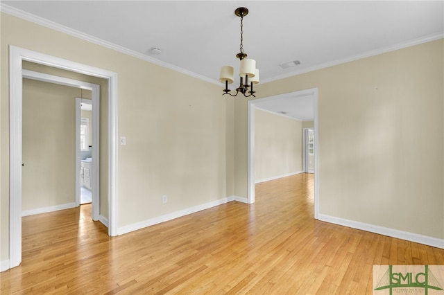 empty room with a chandelier, light hardwood / wood-style floors, and ornamental molding