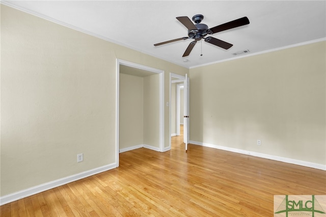 empty room featuring ornamental molding, ceiling fan, and light wood-type flooring