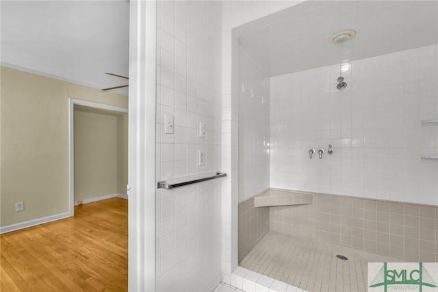 bathroom featuring hardwood / wood-style flooring and a tile shower