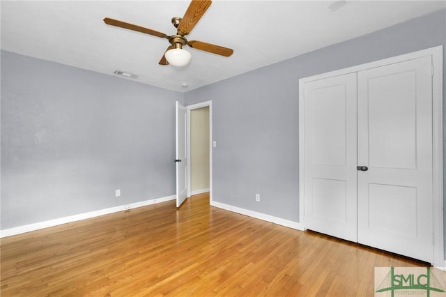 unfurnished bedroom featuring ceiling fan, light hardwood / wood-style floors, and a closet