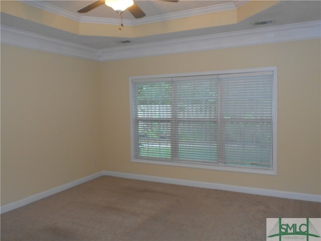 carpeted empty room featuring ceiling fan, a raised ceiling, and crown molding