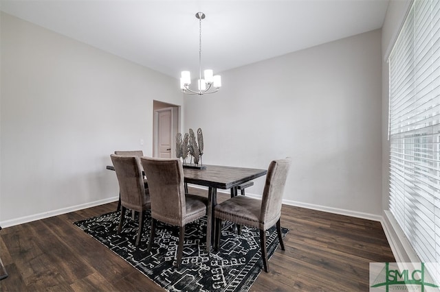 dining space featuring dark hardwood / wood-style flooring and an inviting chandelier