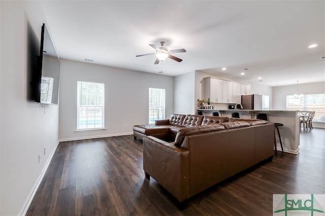 living room with dark wood-type flooring and ceiling fan