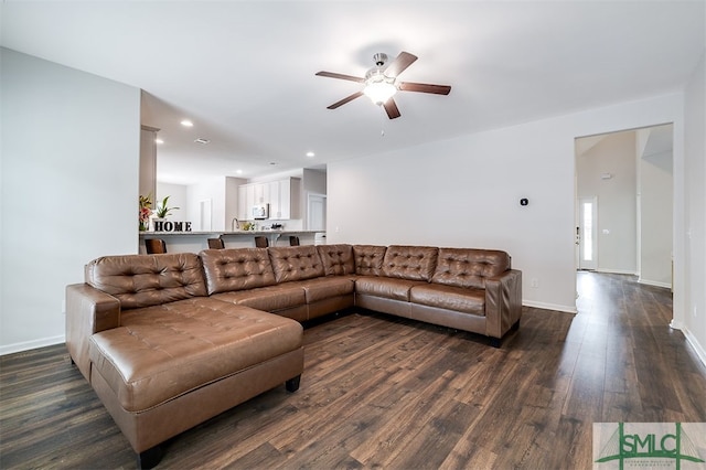 living room with dark wood-type flooring and ceiling fan