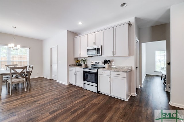 kitchen featuring stainless steel appliances, a healthy amount of sunlight, white cabinetry, and dark hardwood / wood-style flooring