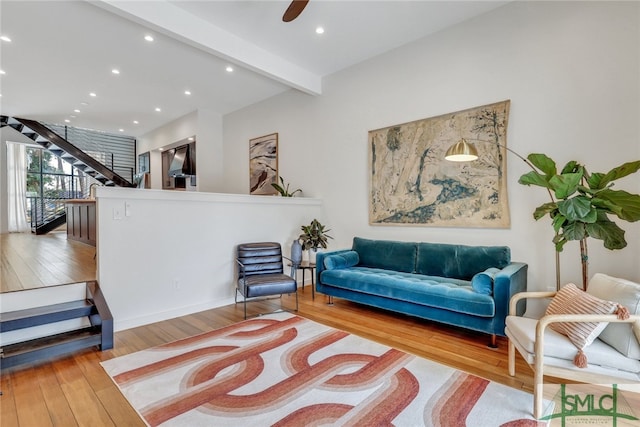 sitting room with beamed ceiling, ceiling fan, and light hardwood / wood-style floors