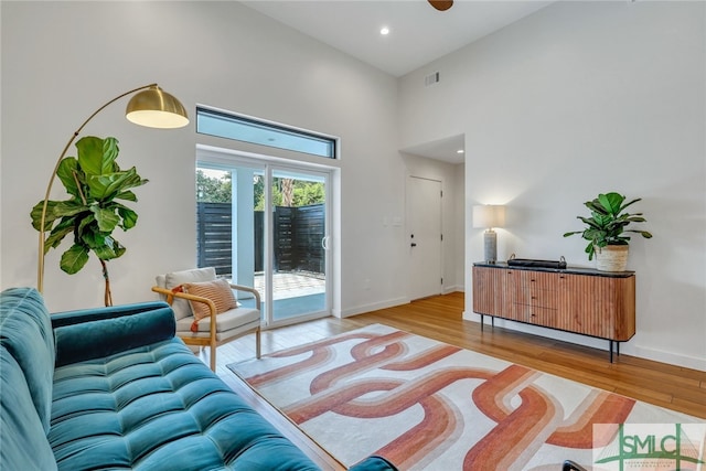 living room featuring hardwood / wood-style flooring and a towering ceiling