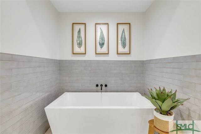 bathroom featuring a tub and tile walls