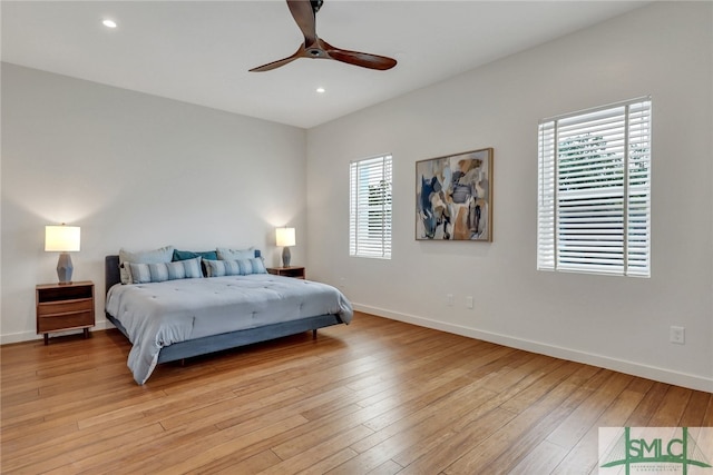 bedroom with light hardwood / wood-style floors, ceiling fan, and multiple windows