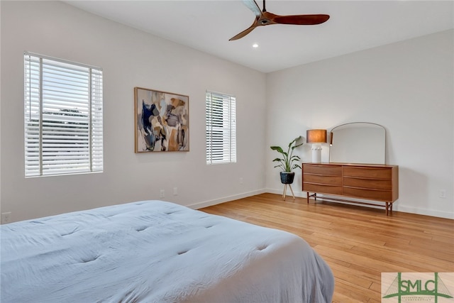 bedroom with multiple windows, hardwood / wood-style floors, and ceiling fan