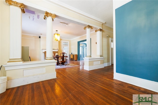 interior space featuring hardwood / wood-style floors, crown molding, and decorative columns