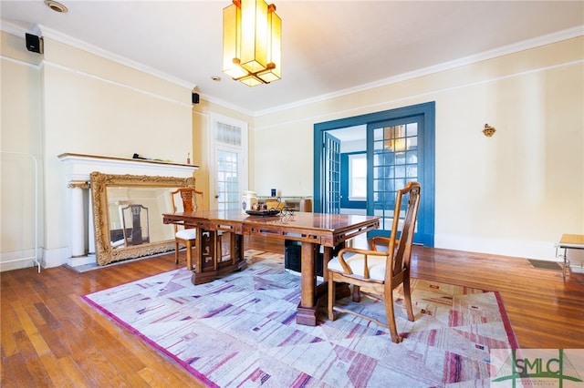 dining room with hardwood / wood-style floors and crown molding