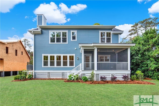 back of property featuring a sunroom and a yard