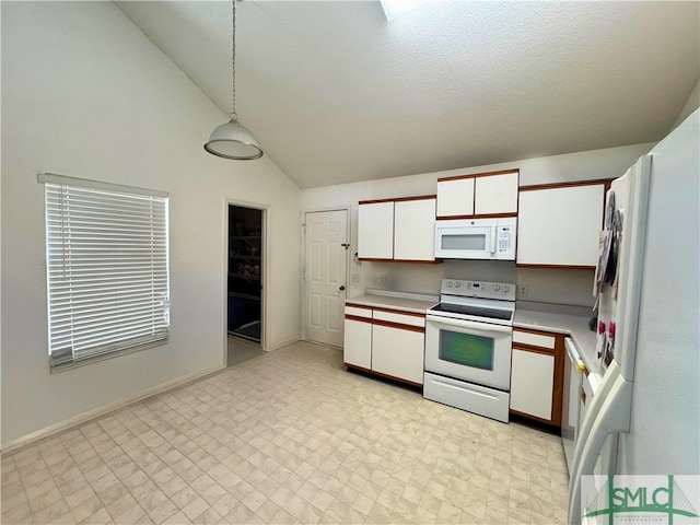 kitchen featuring white appliances, white cabinets, light countertops, pendant lighting, and lofted ceiling