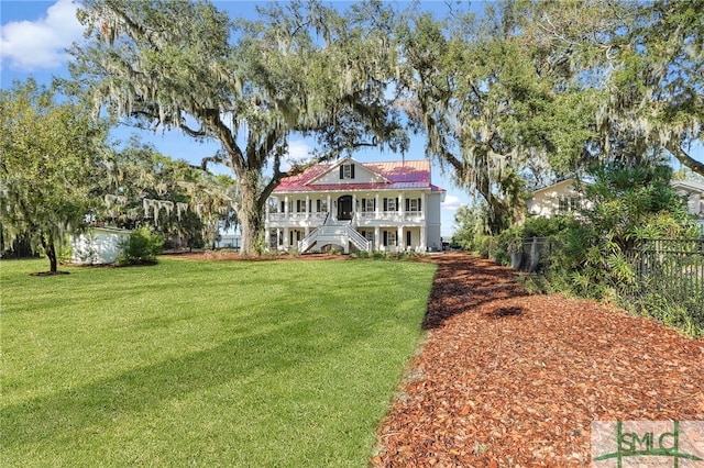 rear view of property featuring a lawn and covered porch