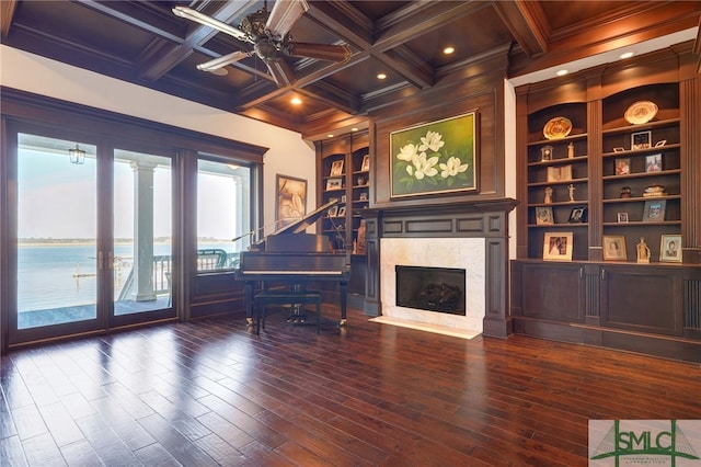 interior space with hardwood / wood-style floors, a water view, and coffered ceiling