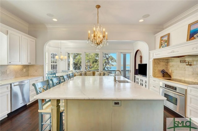 1558 Wilmington Island Rd, Savannah, GA 31410 - kitchen with appliances with stainless steel finishes, a chandelier, arched walkways, a kitchen breakfast bar, and dark wood-style floors
