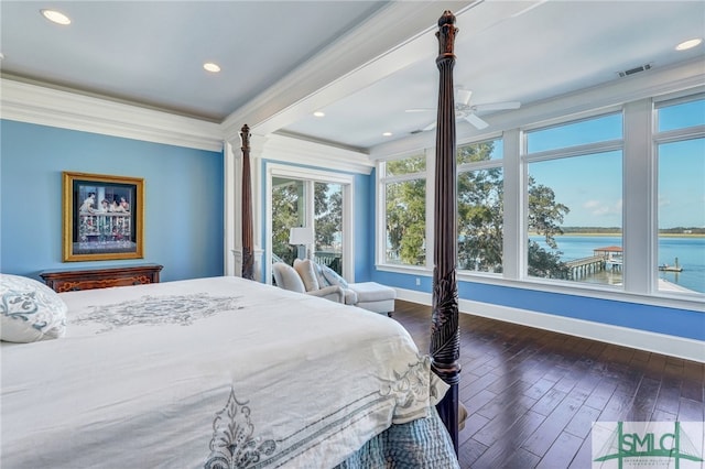 bedroom with ornamental molding, dark hardwood / wood-style flooring, decorative columns, a water view, and ceiling fan