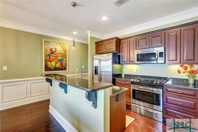 1558 Wilmington Island Rd, Savannah, GA 31410 - kitchen with stainless steel appliances, crown molding, a kitchen breakfast bar, dark wood-style flooring, and decorative light fixtures
