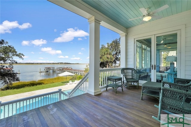 deck with a water view and ceiling fan