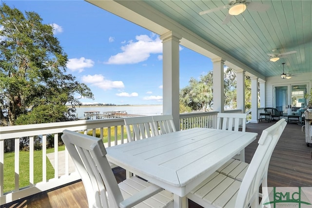 wooden terrace featuring a water view and ceiling fan