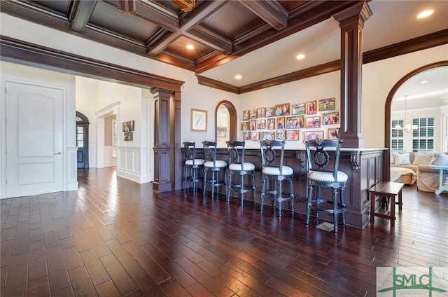 bar with beamed ceiling, dark hardwood / wood-style floors, crown molding, and coffered ceiling