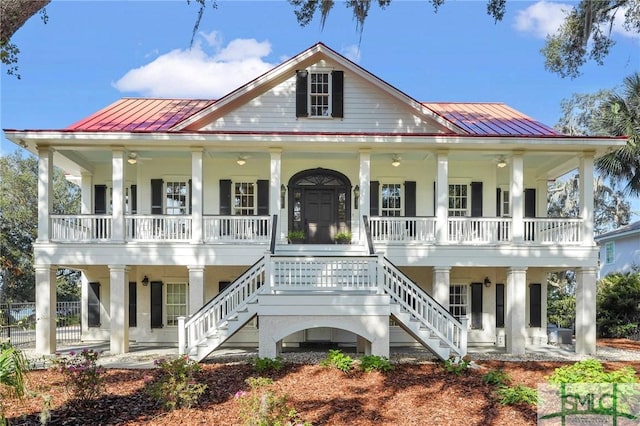 1558 Wilmington Island Rd, Savannah, GA 31410 - neoclassical home with covered porch, a metal roof, stairs, and a standing seam roof