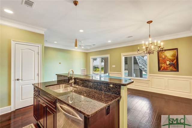 kitchen with dark hardwood / wood-style flooring, dark stone counters, hanging light fixtures, sink, and stainless steel dishwasher