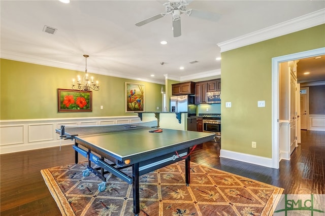 playroom with dark hardwood / wood-style flooring, ceiling fan with notable chandelier, and crown molding