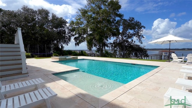 view of pool featuring a patio, an in ground hot tub, and a water view