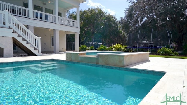 1558 Wilmington Island Rd, Savannah, GA 31410 - swimming pool featuring an in-ground hot tub, stairway, a patio, and a trampoline